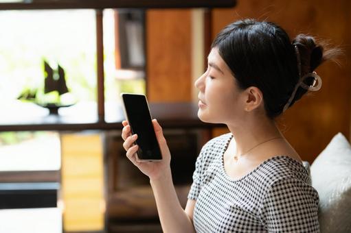 スマートフォンを持つ女性 スマートフォンを持つ女性 女性,スマホ,携帯電話の写真素材