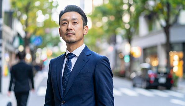 街中を歩くスーツを着ているビジネスマンの写真