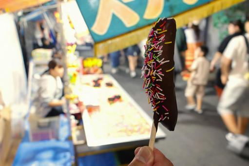 夏祭りでチョコバナナを持つ男性の手 夏祭りでチョコバナナを持つ男性の手 チョコバナナ,祭り,屋台の写真素材