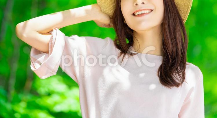 麦わら帽子をかぶる女性・熱中症対策 女性,笑顔,夏の写真素材