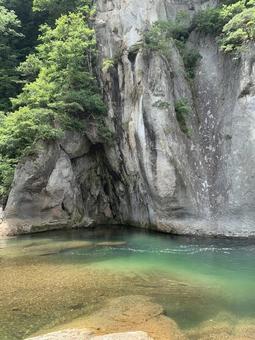 切り立つ岩壁とエメラルドグリーンの渓流 切り立つ岩壁とエメラルドグリーンの渓流の写真