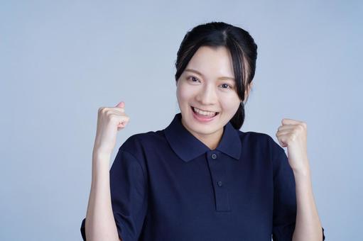 紺色の服の女性がガッツポーズ 女性,ガッツポーズ,笑顔の写真素材