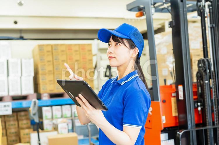 荷物を管理する若い女性 倉庫,工場,笑顔の写真素材