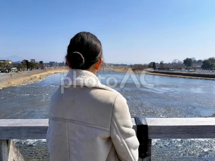 京都の嵐山　渡月橋から桂川を眺める女性 若い女性,後姿,渡月橋の写真素材