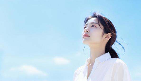 青空を背景にたたずむ女性のポートレート 青空を背景にたたずむ女性のポートレートの写真