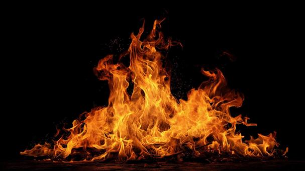 黒い背景で燃え盛る炎と火の粉の写真