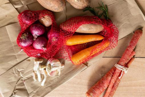 ネットに入った玉ネギなどの野菜 ニンジン,細長い,オレンジ色の写真素材