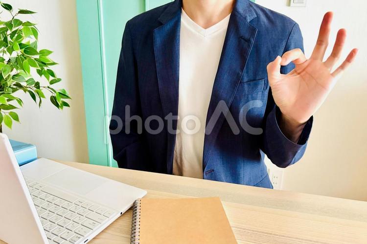 室内でOKのポーズをする座った男性 ok,オッケー,まるの写真素材