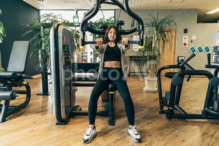 スポーツジムで体を鍛える女性（胸筋） スポーツジム,筋トレ,運動の写真素材