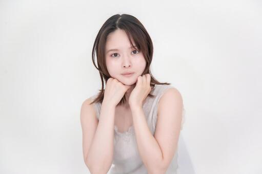あごをのせてじっとカメラを見つめる女性 美容,ビューティー,スキンケアの写真素材