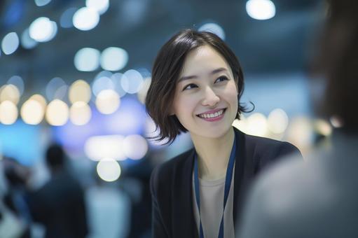 イベント会場で談笑する女性 イベント会場で談笑する女性の写真
