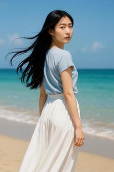 海辺で振り返る青ブラウスと白スカート女性 海辺で振り返る青ブラウスと白スカート女性の写真