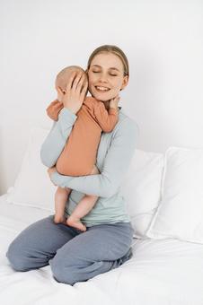 目を瞑り縦抱きで抱っこする笑顔女性 目を瞑り縦抱きで抱っこする笑顔女性 親子,母子,赤ちゃんの写真素材