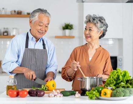 キッチンで会話しながら料理するシニア夫婦 キッチンで会話しながら料理するシニア夫婦の写真