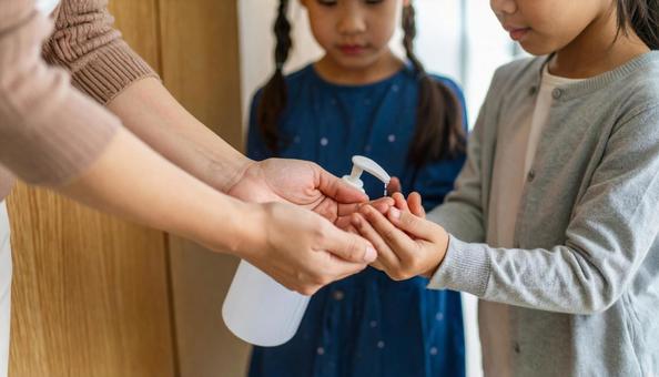 病室に入る前に手指消毒をする見舞客の家族 病室に入る前に手指消毒をする見舞客の家族の写真