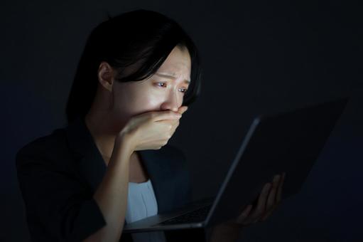 女性がノートPCを見て考え込む 女性,ノートパソコン,持つの写真素材