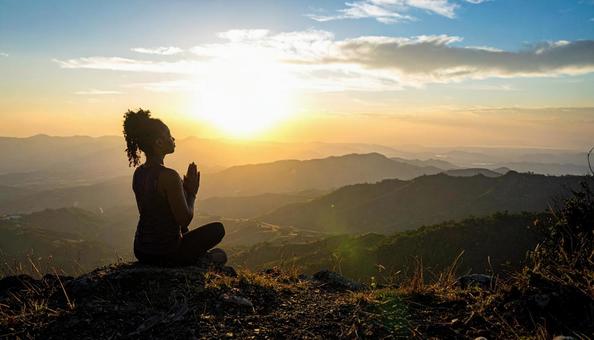 夕焼けに手を合わせて祈る女性 夕焼けに手を合わせて祈る女性の写真