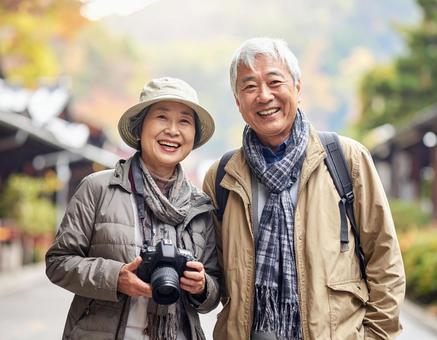 カメラを持って旅する仲良しシニア夫婦 カメラを持って旅する仲良しシニア夫婦の写真