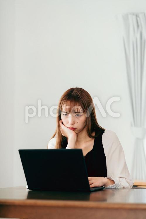 パソコンの画面を見ながら考える女性 女性,在宅ワーク,話すの写真素材