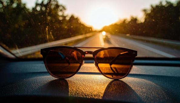 車のダッシュボードに置かれたサングラス 車のダッシュボードに置かれたサングラスの写真