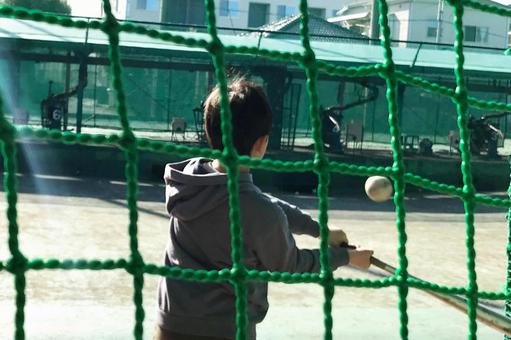 野球ボールをバットで打つ子ども 野球ボールをバットで打つ子どもの写真