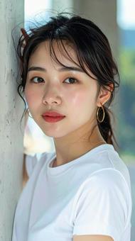 白いTシャツの女性が壁際でポーズをとるの写真