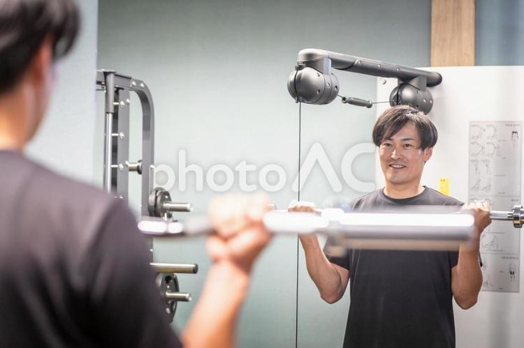 バーベルのシャフトでフォームをチェックする男性（笑顔） バーベル,筋トレ,シャフトの写真素材