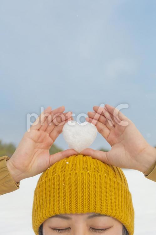 ハート型の雪を頭の上に持つ女性 冬,雪,人物の写真素材