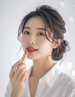 リップを塗る若い女性の美容ポートレートの写真