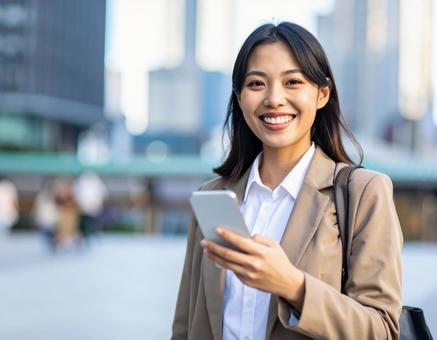 携帯電話を持つ笑顔の女性　ビジネスの写真