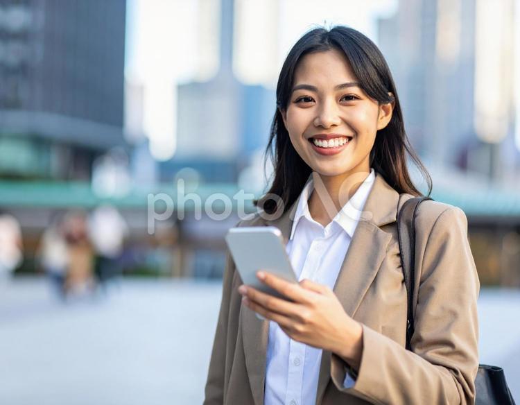 携帯電話を持つ笑顔の女性　ビジネス 女性,笑顔,スーツの写真素材