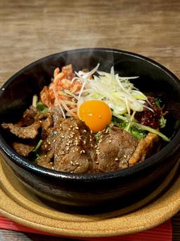 彩り豊かな石焼きビビンバ、熱々湯気濃厚卵 彩り豊かな石焼きビビンバ、熱々湯気濃厚卵の写真
