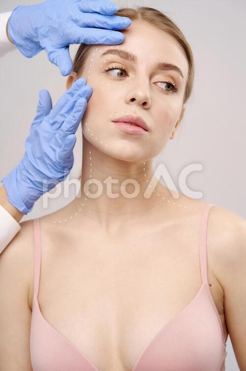 美容整形外科医に顔を触られている女性 美容整形,女性,外国人の写真素材
