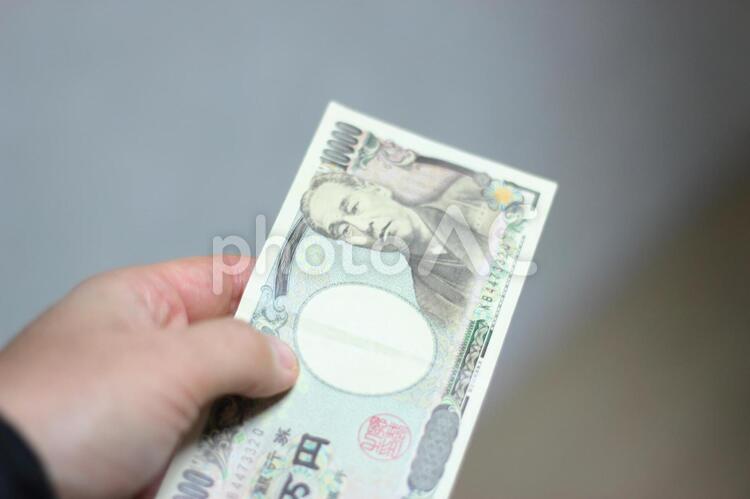 一万円を支払う人 money,お札,お金の写真素材