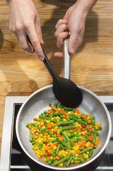 フライパンで野菜を炒める手 フライパンで野菜を炒める手 キュイジーヌ,キッチン,厨房の写真素材
