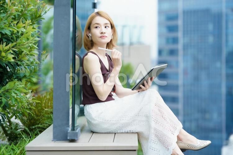 街なかで仕事をする女性  女性,仕事,ライフスタイルの写真素材