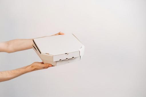両手で2箱のピザ箱を差し出す 配達,フードデリバリー,テイクアウトの写真素材