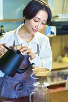 コーヒーを淹れる店員 カフェ 喫茶店 コーヒーを淹れる店員 カフェ 喫茶店 コーヒー,主婦,エプロンの写真素材