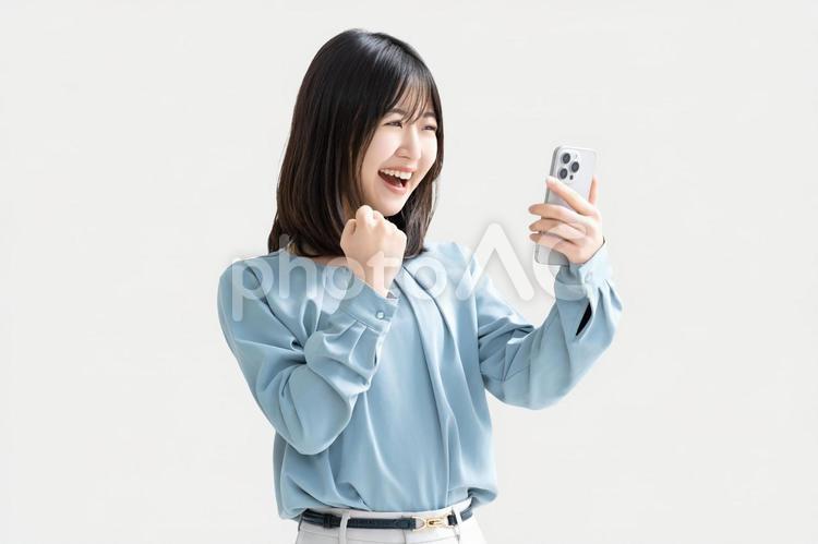 スマホを見て喜ぶ女性・ビジネスウーマン 女性,スマホ,スマートフォンの写真素材