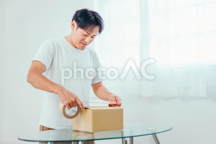 荷造りする男性（笑顔） 荷造り,梱包,引越しの写真素材