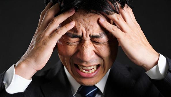 頭を抱えるビジネスマン 頭を抱えるビジネスマンの写真