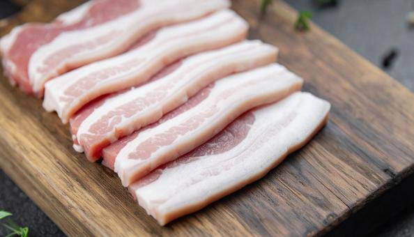 カッティングボードの上の豚バラ肉 カッティングボードの上の豚バラ肉の写真