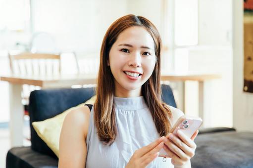 リビングでスマホを使う女性 phone リビングでスマホを使う女性 phone 女性,スマホ,スマートフォンの写真素材