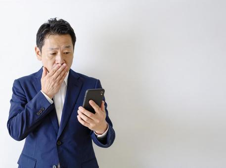スマホ 50代 笑顔 悪い知らせ の写真
