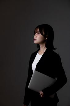 ノートパソコンを抱えるビジネスウーマン ノートパソコンを抱えるビジネスウーマン 女性,ビジネスウーマン,人物の写真素材