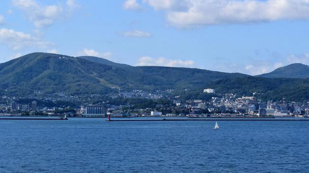 洋上から望む小樽の街並みと山 小樽,北海道,街並みの写真素材