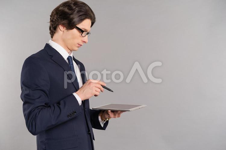 タブレットとタッチペンを持つメガネの男性 男性,タブレット,持つの写真素材