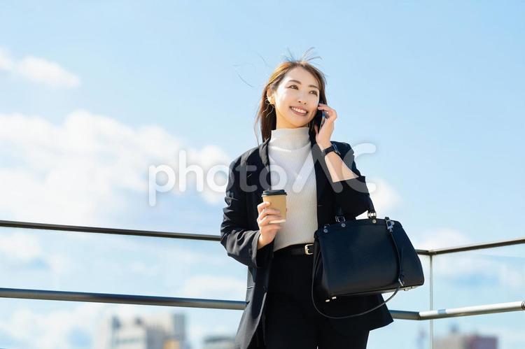 スマホで話す笑顔の女性・ビジネスウーマン 女性,スマホ,スマートフォンの写真素材