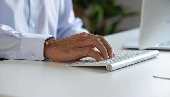 キーボードを叩くビジネスマンの手元 キーボードを叩くビジネスマンの手元の写真