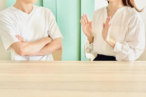 腕を組む男性と弁解する女性 腕を組む男性と弁解する女性の写真
